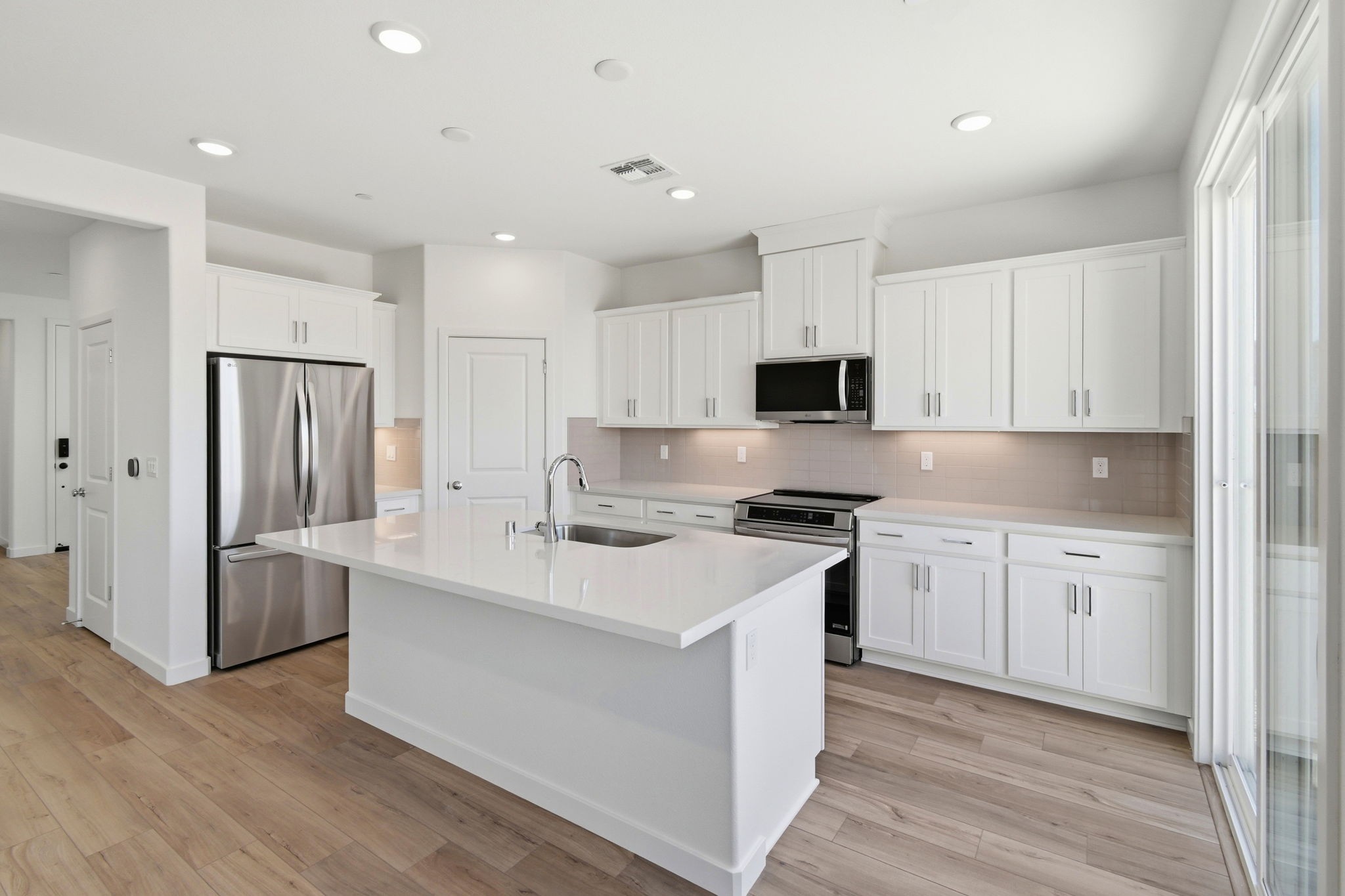 A kitchen with white cabinets.