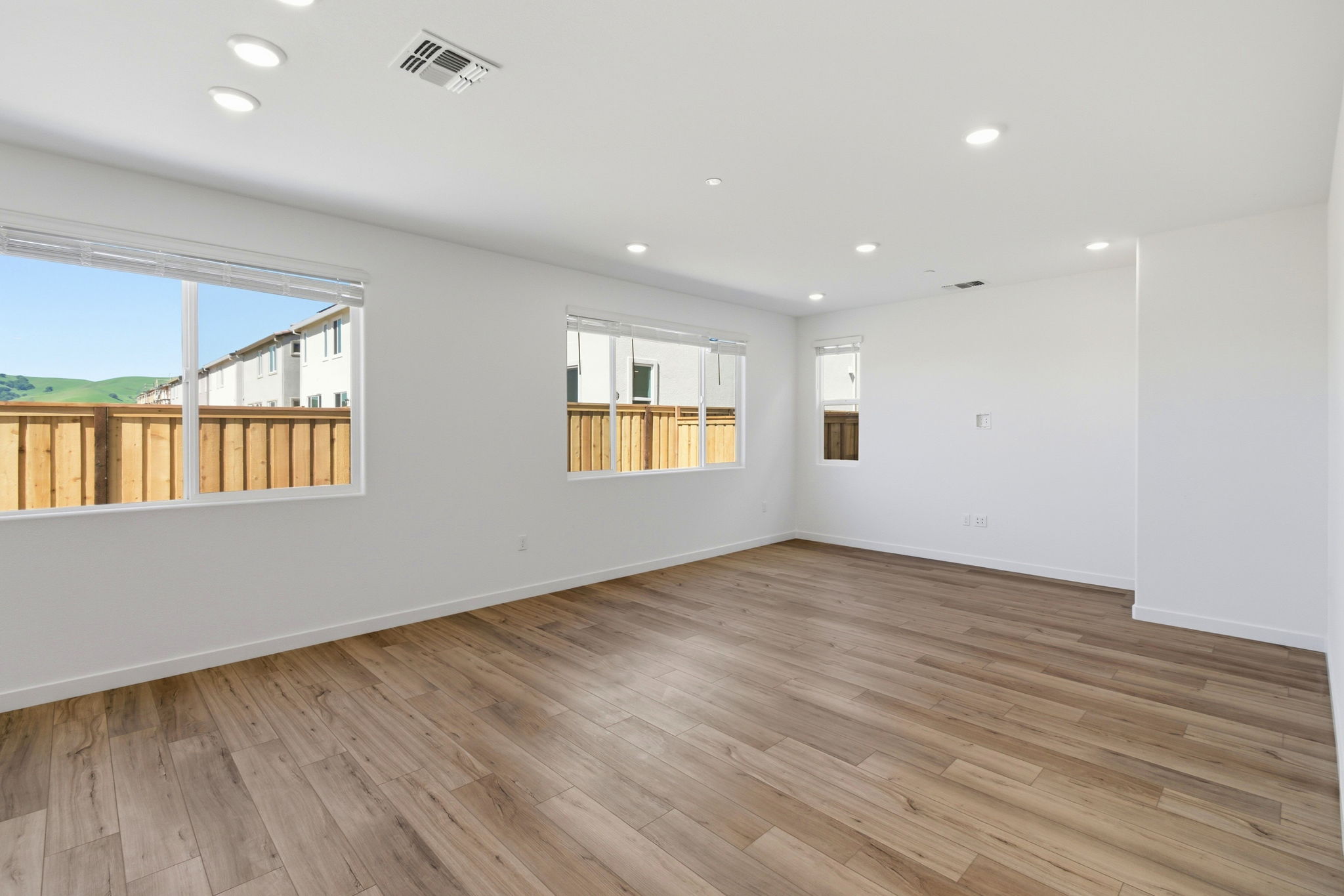 A room with a wood floor and a wood floor with a window.