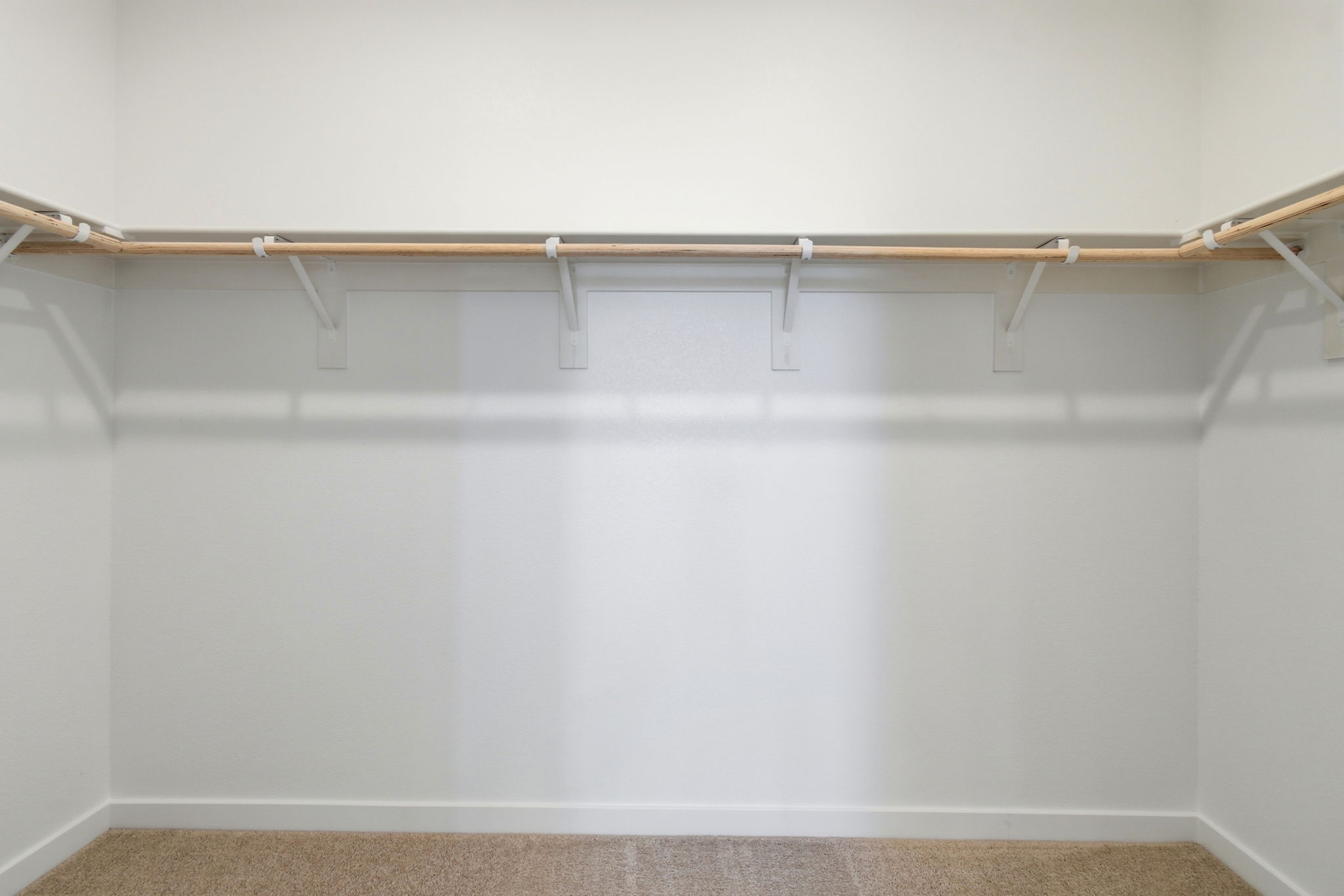 A white wall with a metal bar.