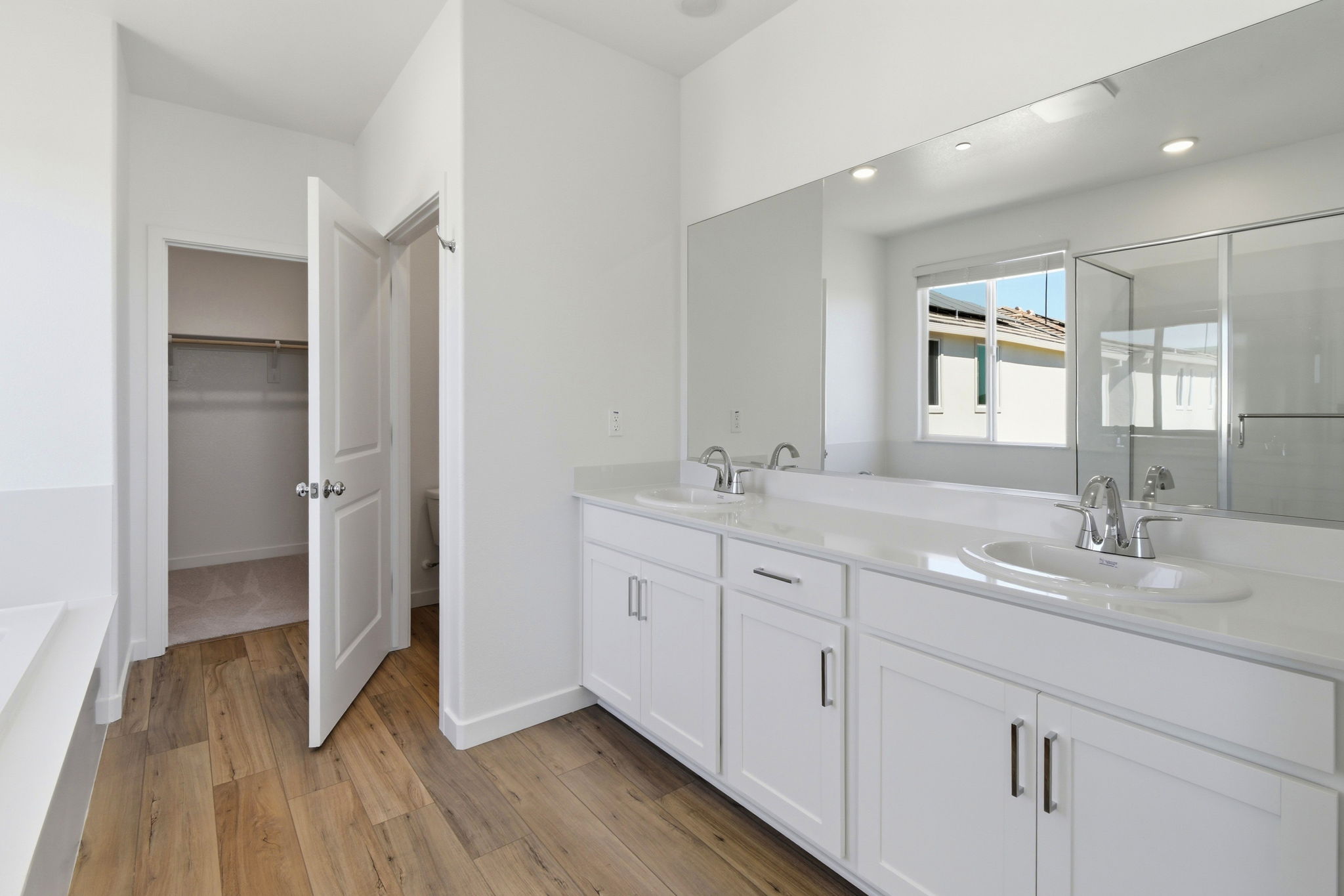 A bathroom with white cabinets.