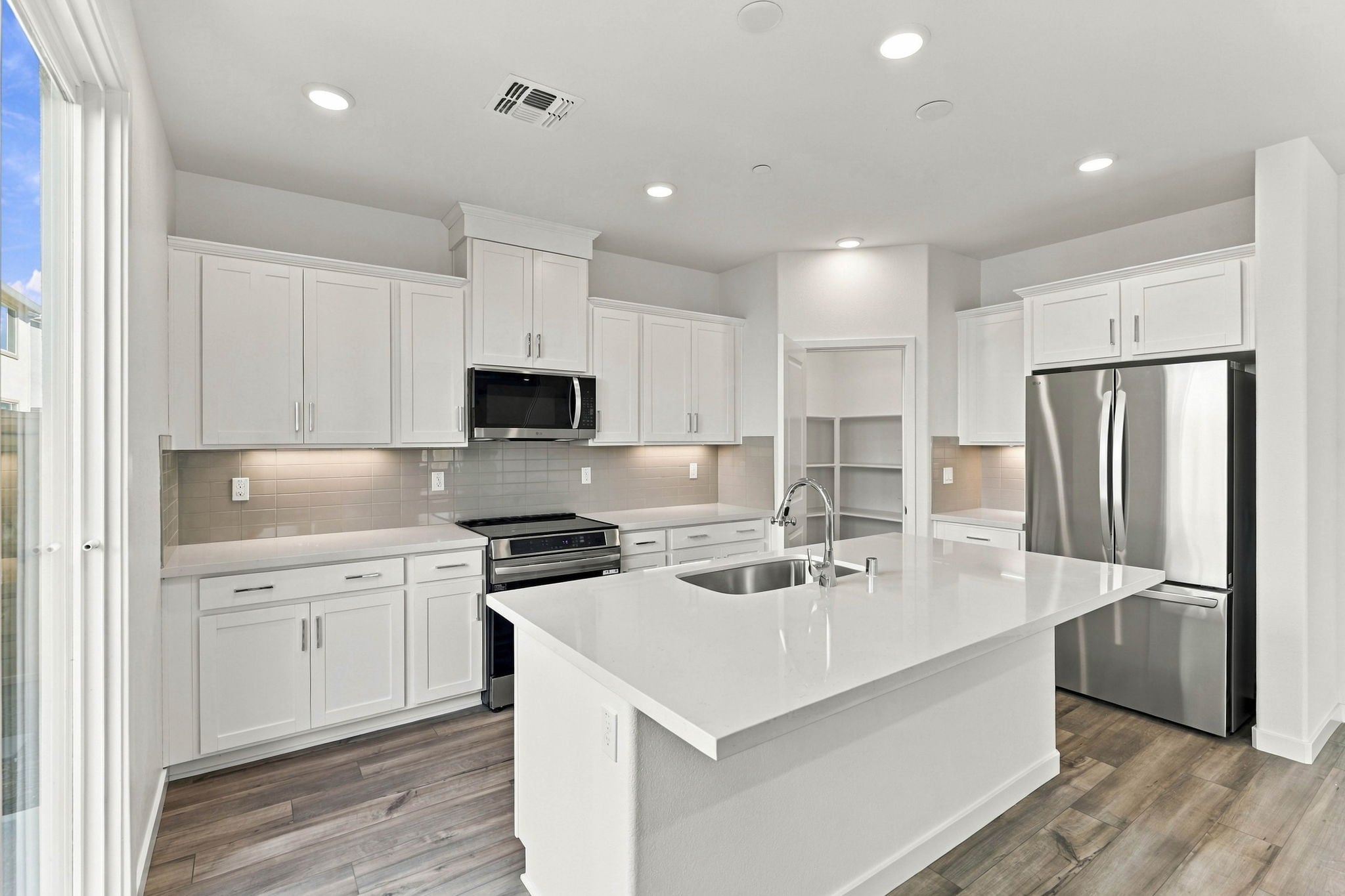 A kitchen with white cabinets.