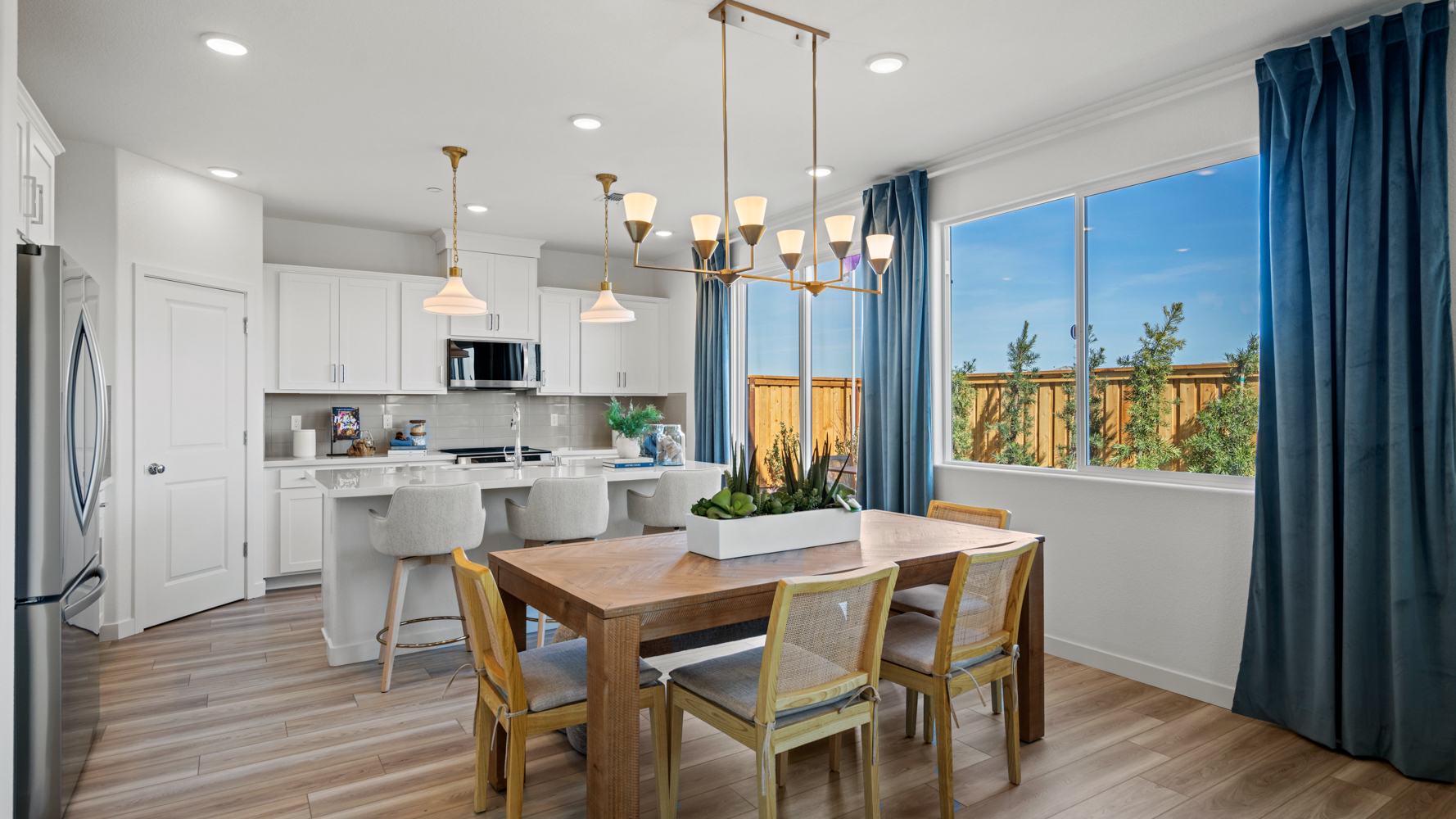A kitchen with a dining table and a large window.