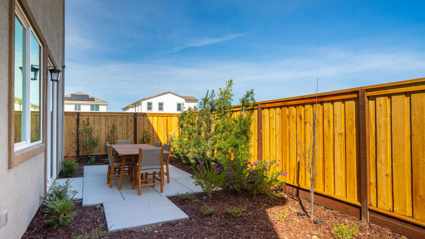 A backyard with a table and chairs.