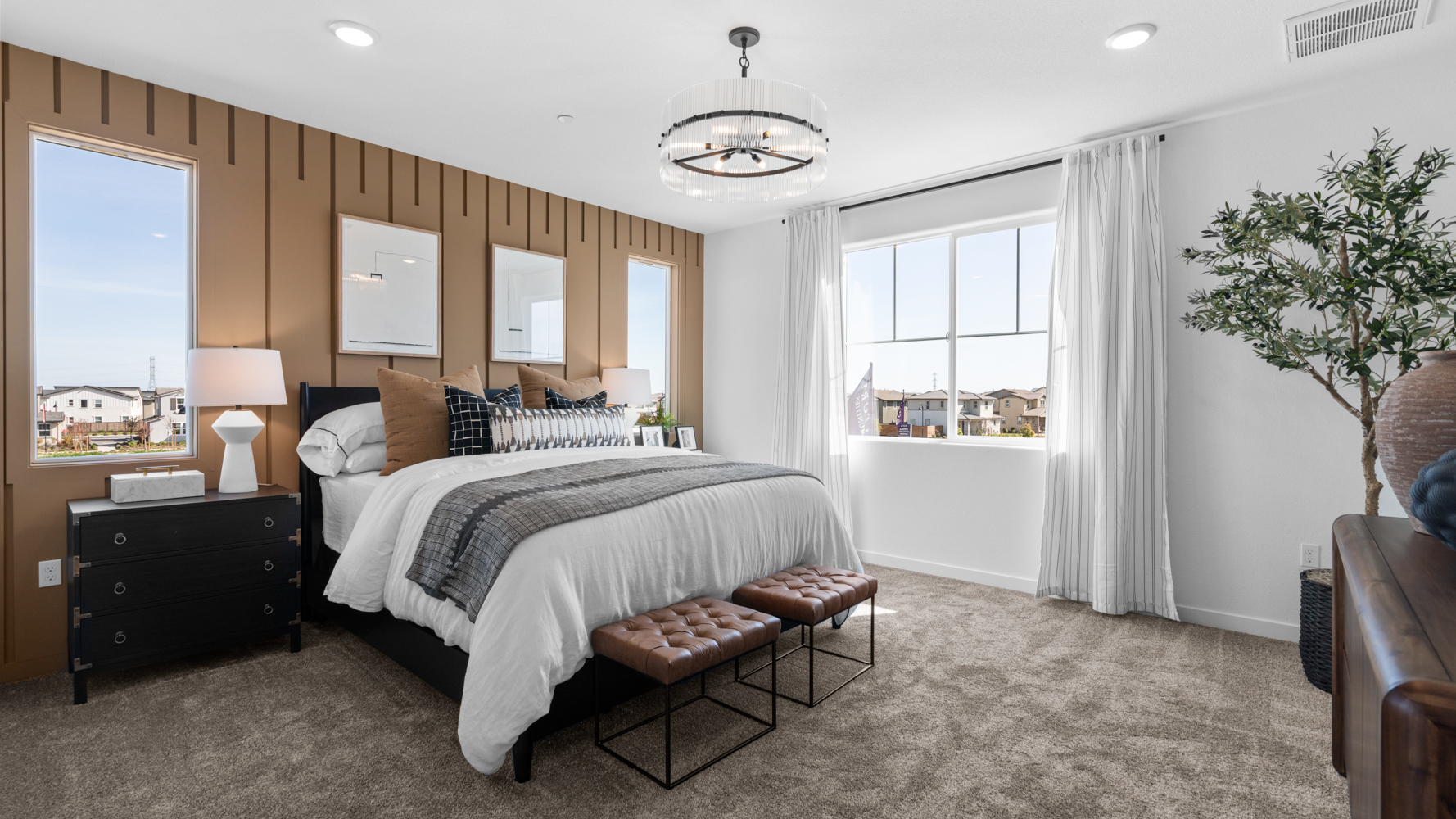 A bedroom with a bed and a bench.