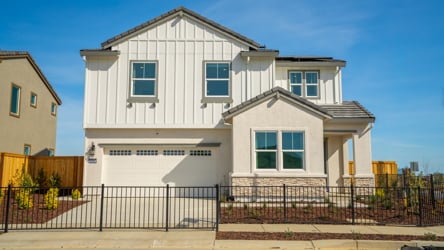 A white house with a black fence.