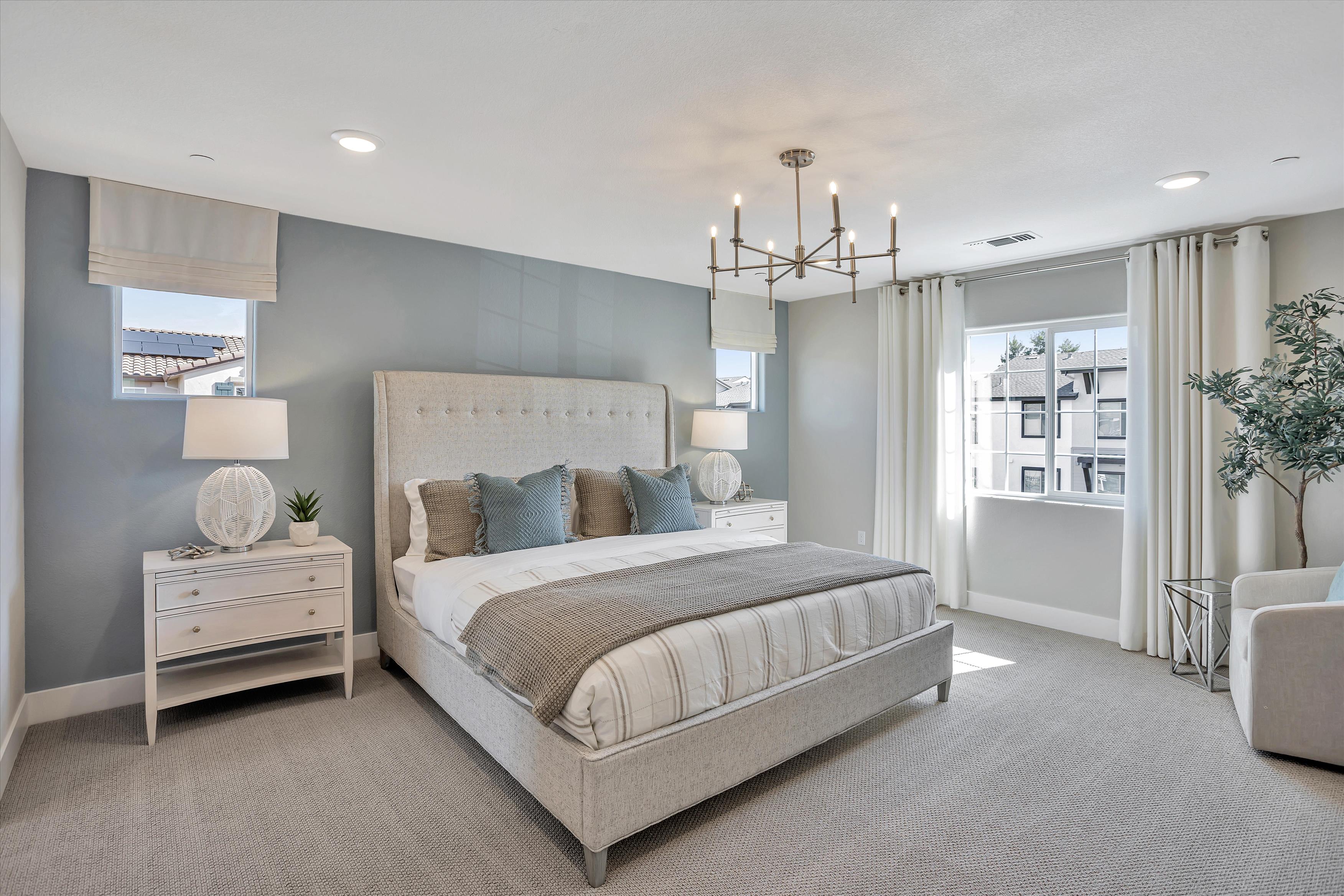 A bedroom with a bed and a chandelier.