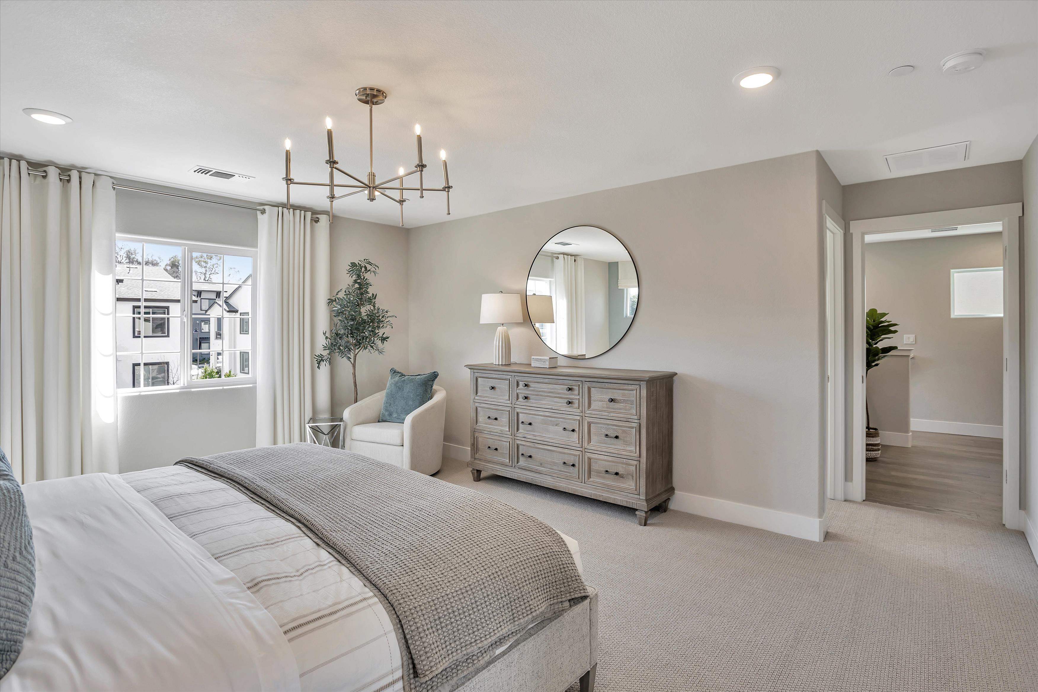 A bedroom with a large mirror.