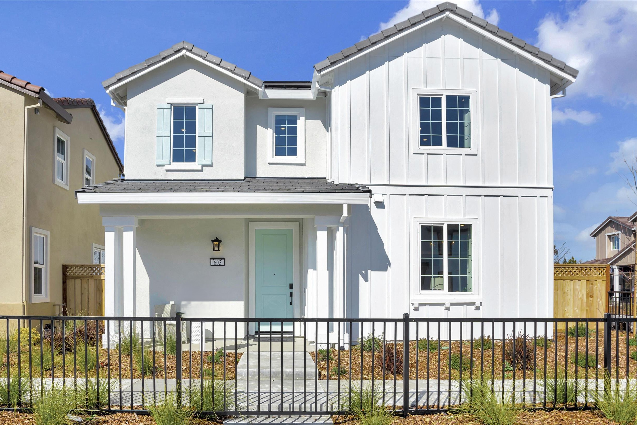 A white house with a black fence.