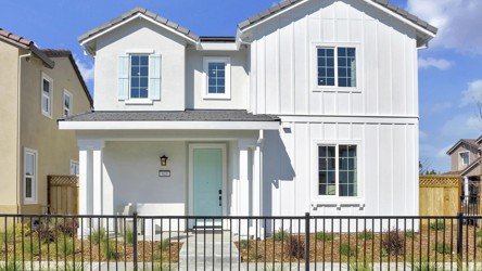 A white house with a black fence.