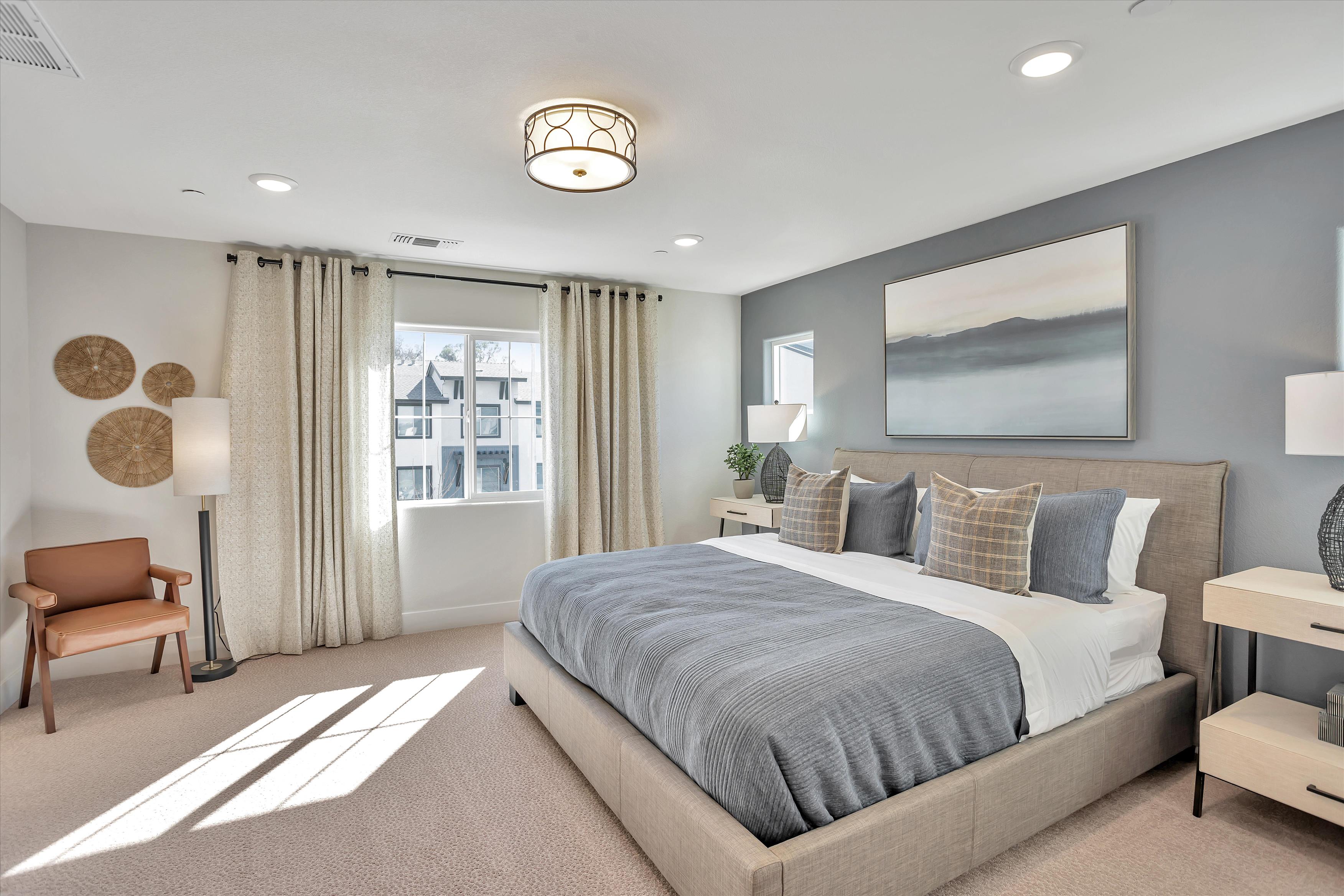 A bedroom with a bed and a chair.