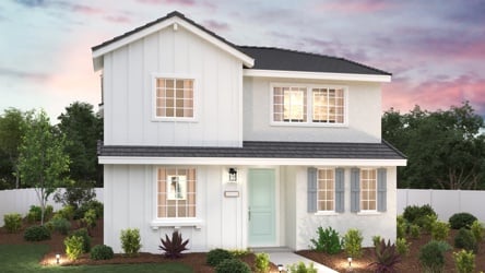 A white house with a green lawn.