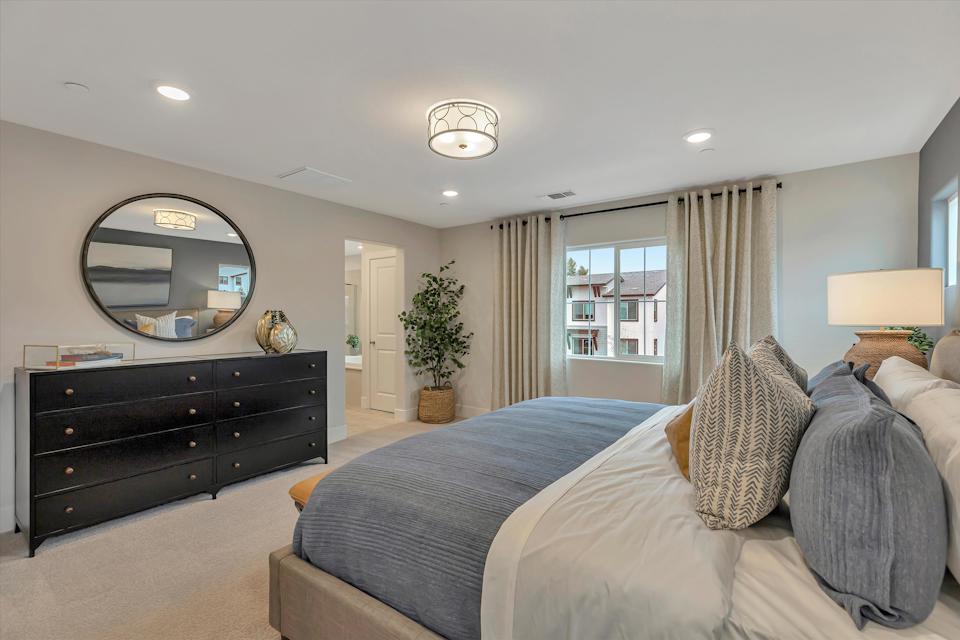 A bedroom with a large mirror.