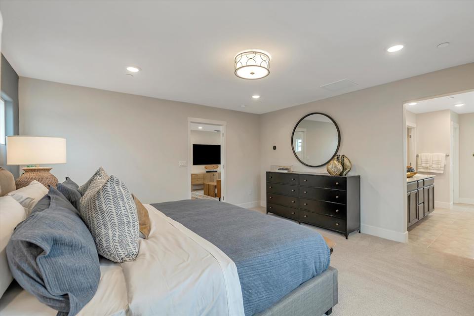 A bedroom with a bed and a mirror.