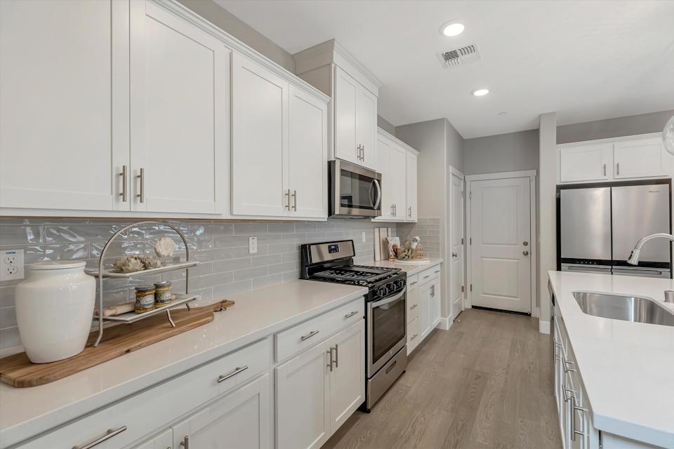 A kitchen with white cabinets.