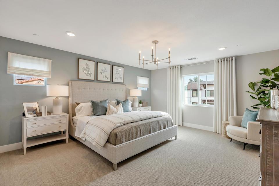 A bedroom with a bed and a chair.