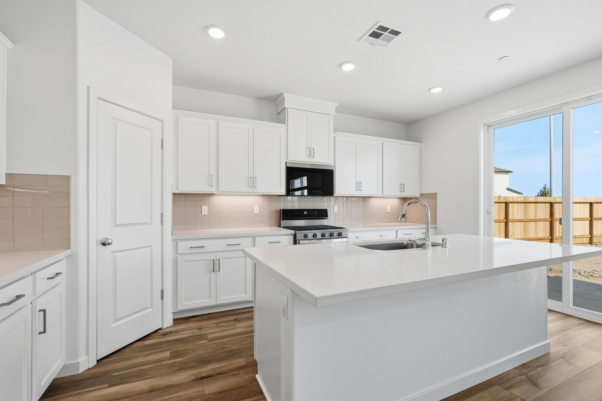 A kitchen with white cabinets.
