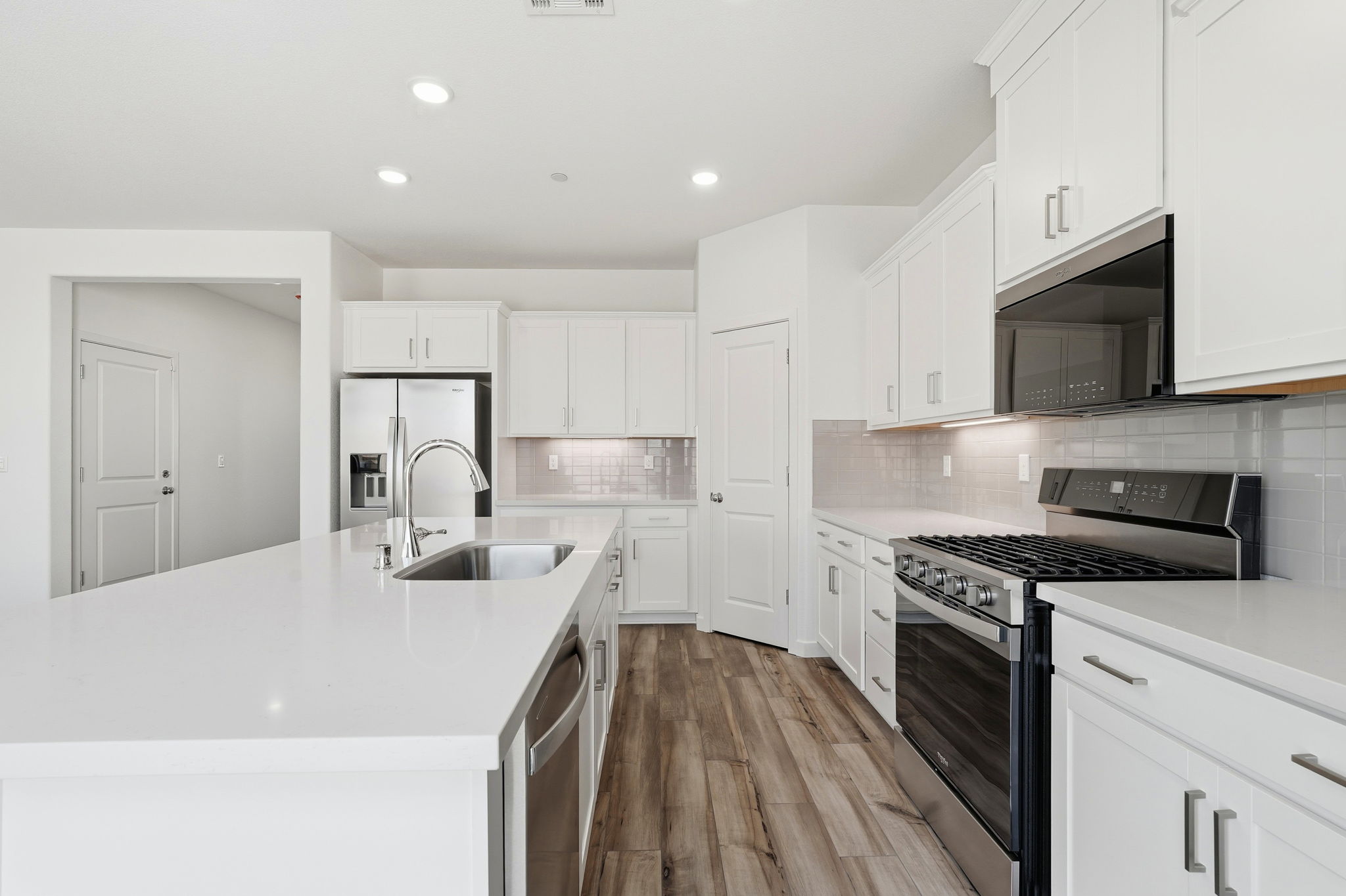 A kitchen with white cabinets.
