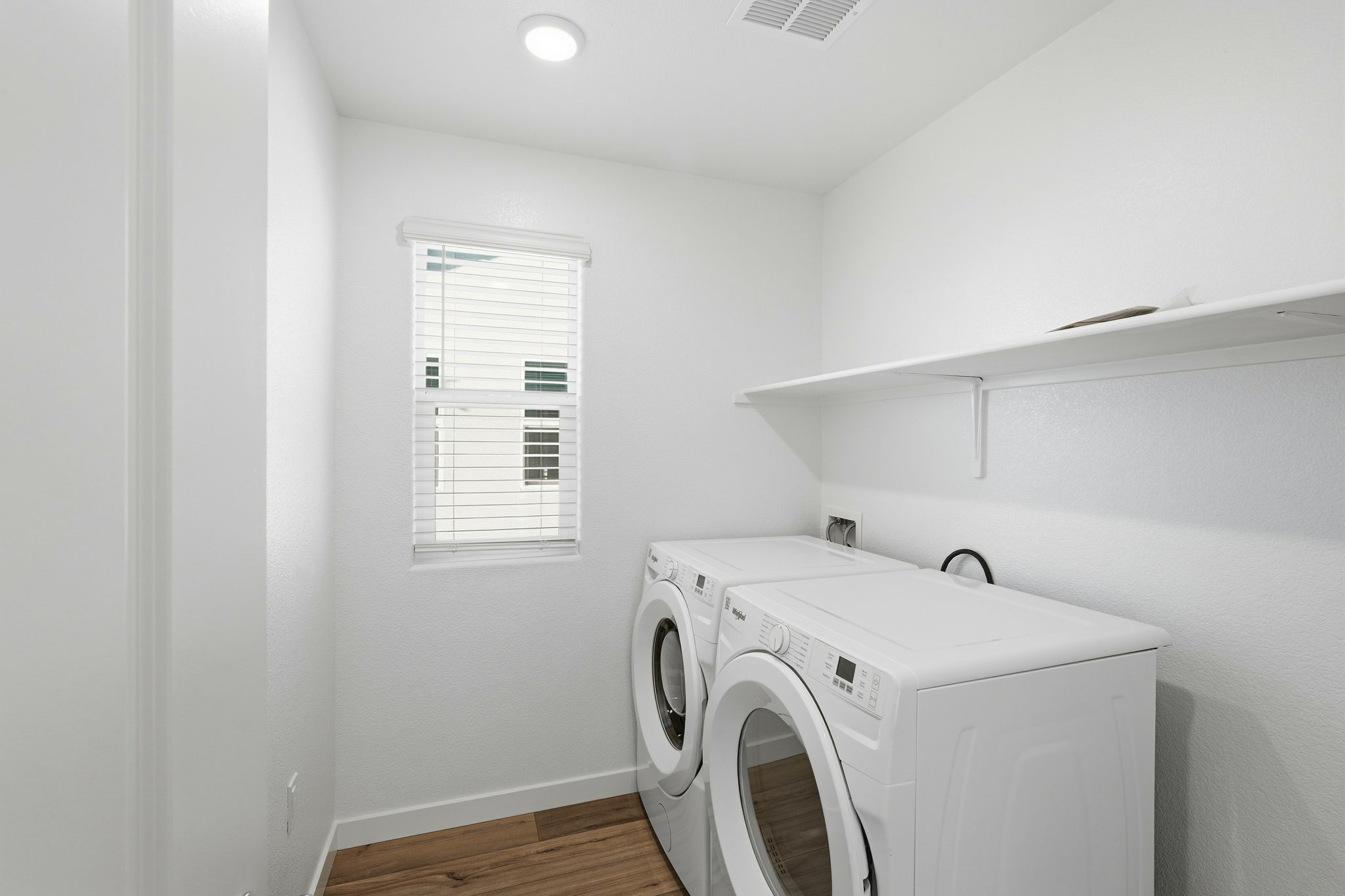 A white laundry room with a washer and dryer.