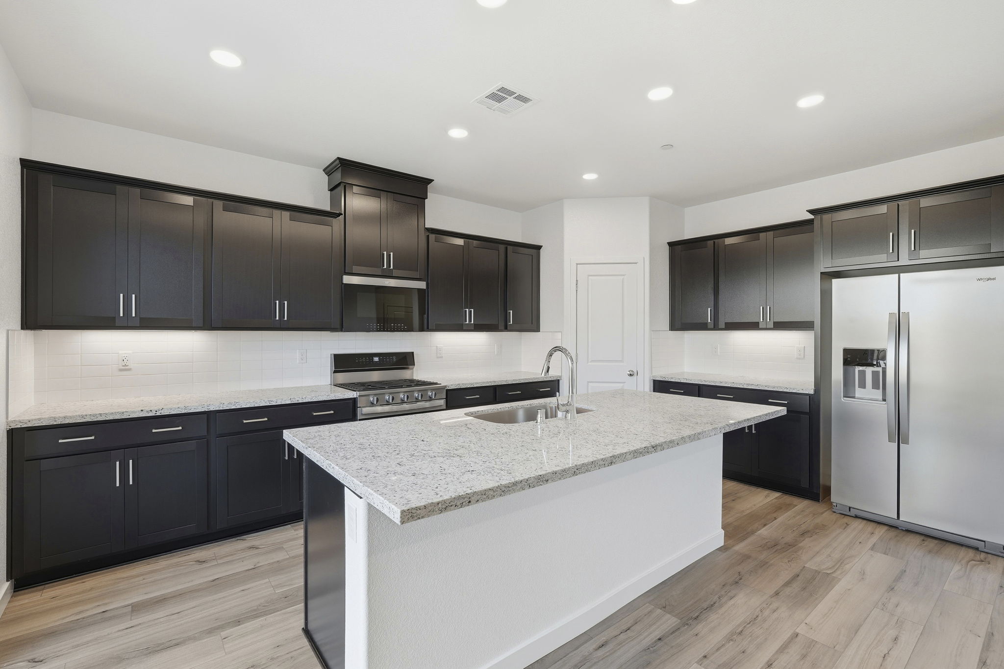 A kitchen with black cabinets.