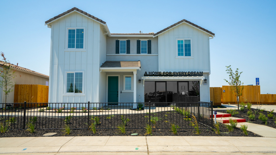 A white building with a black fence.
