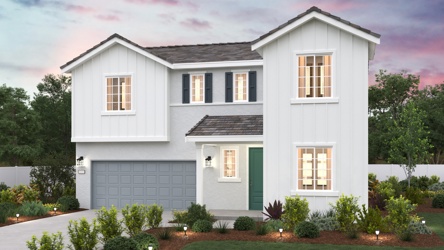 A white house with a green lawn.