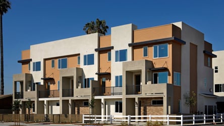 A large building with a white fence.