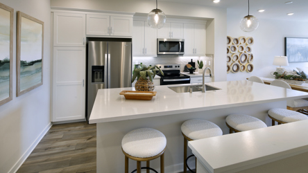 A kitchen with a bar stool and a white counter top.