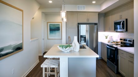 A kitchen with a bar stool and a table.