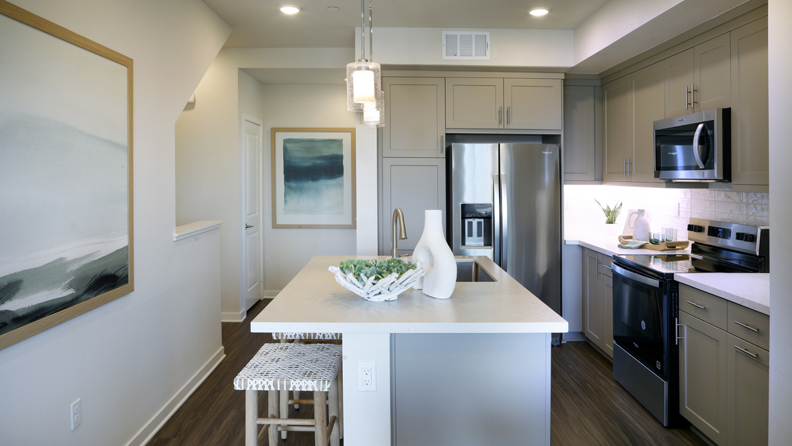 A kitchen with a bar stool and a table.