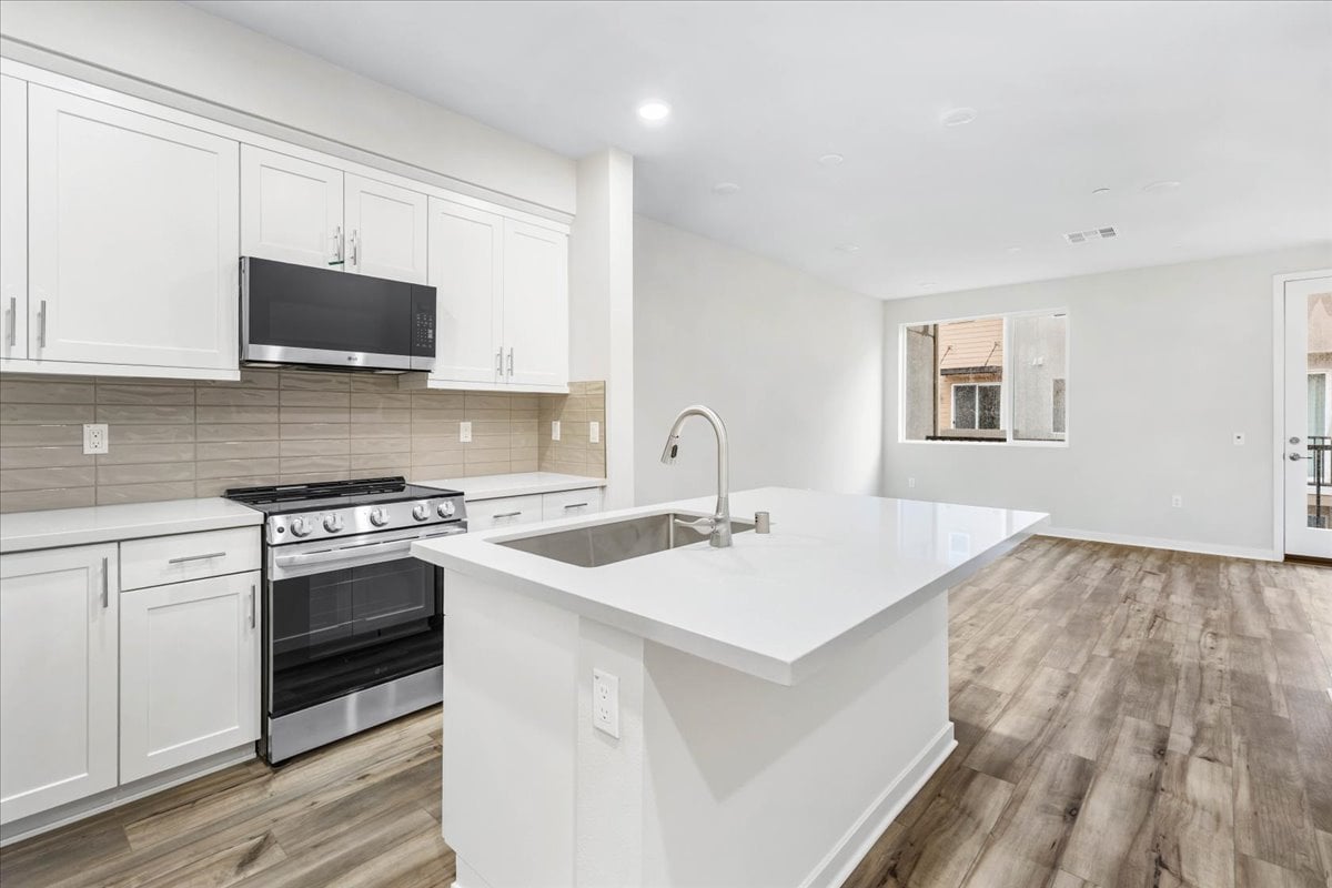 A kitchen with white cabinets.