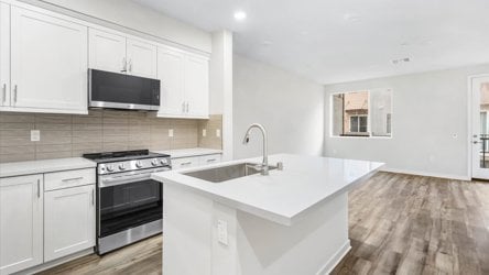 A kitchen with white cabinets.