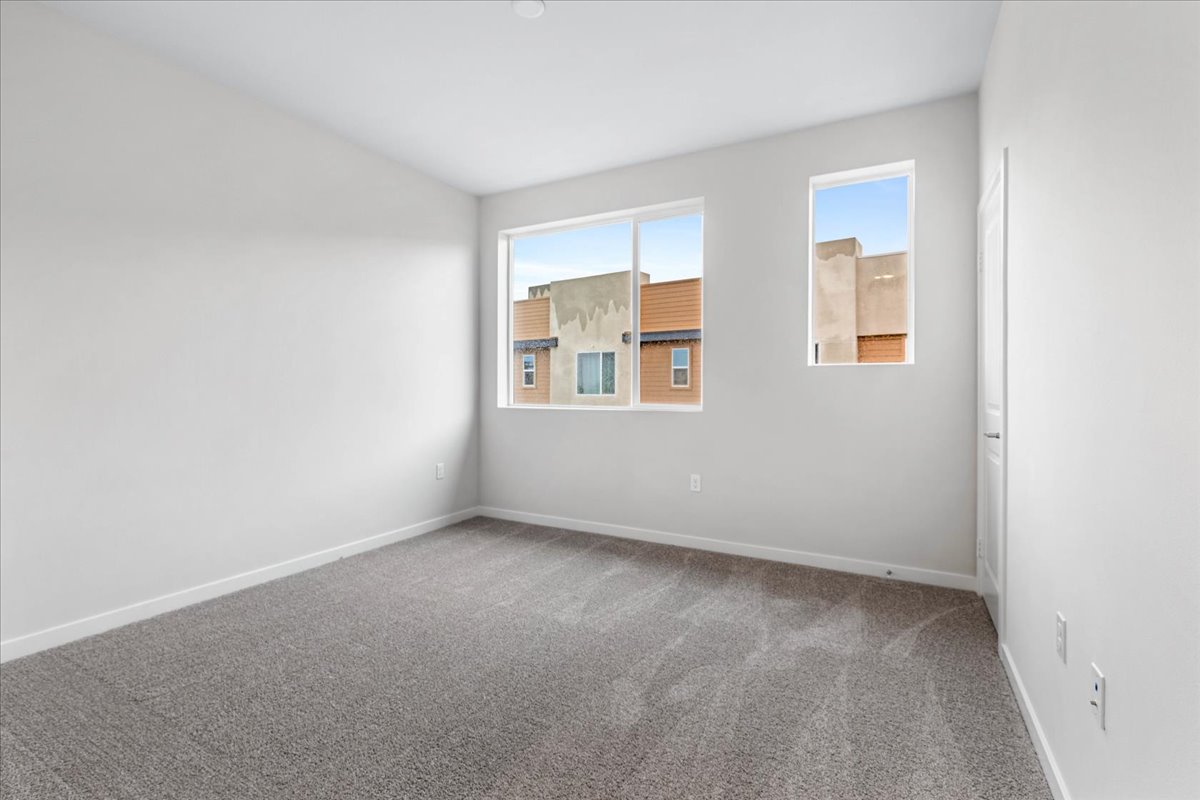 A room with a window and a carpet.