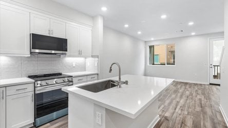 A kitchen with white cabinets.