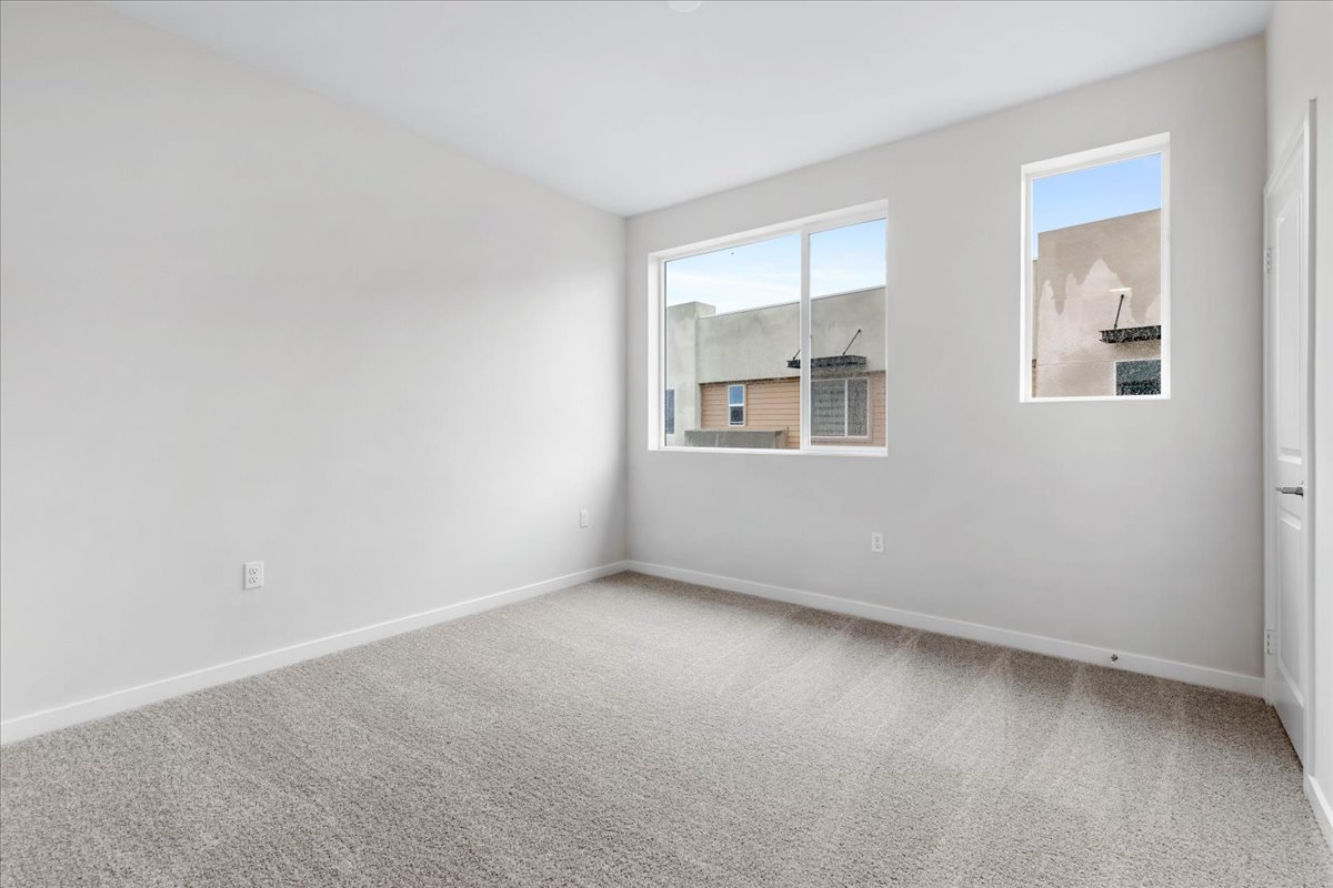A room with a window and a rug.
