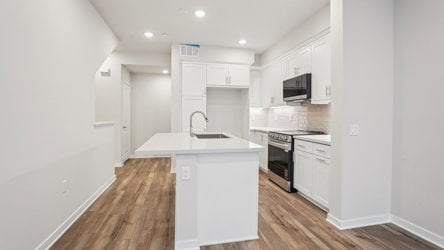 A kitchen with white cabinets.
