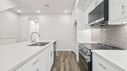 A kitchen with white cabinets.