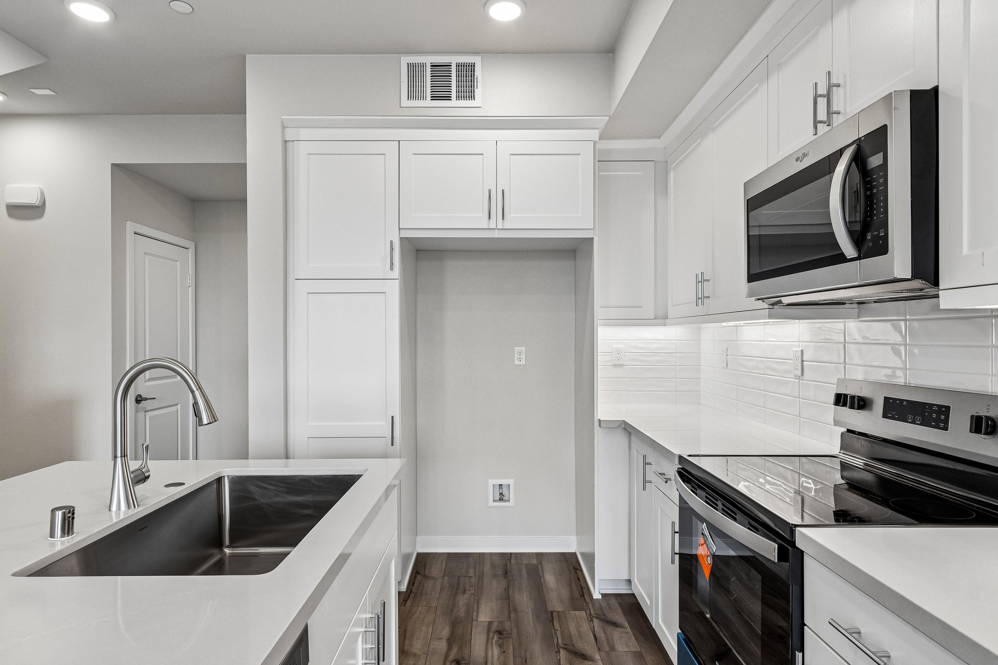 A kitchen with white cabinets.