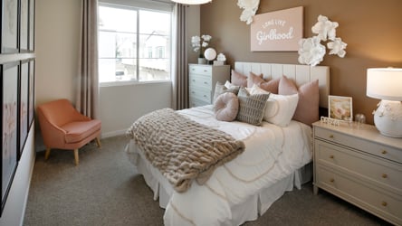 A bedroom with a bed and a chair.