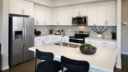 A kitchen with white cabinets.