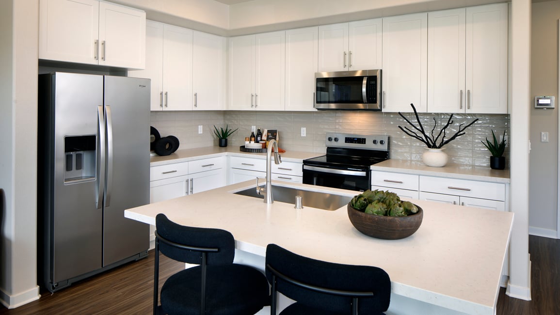 A kitchen with white cabinets.