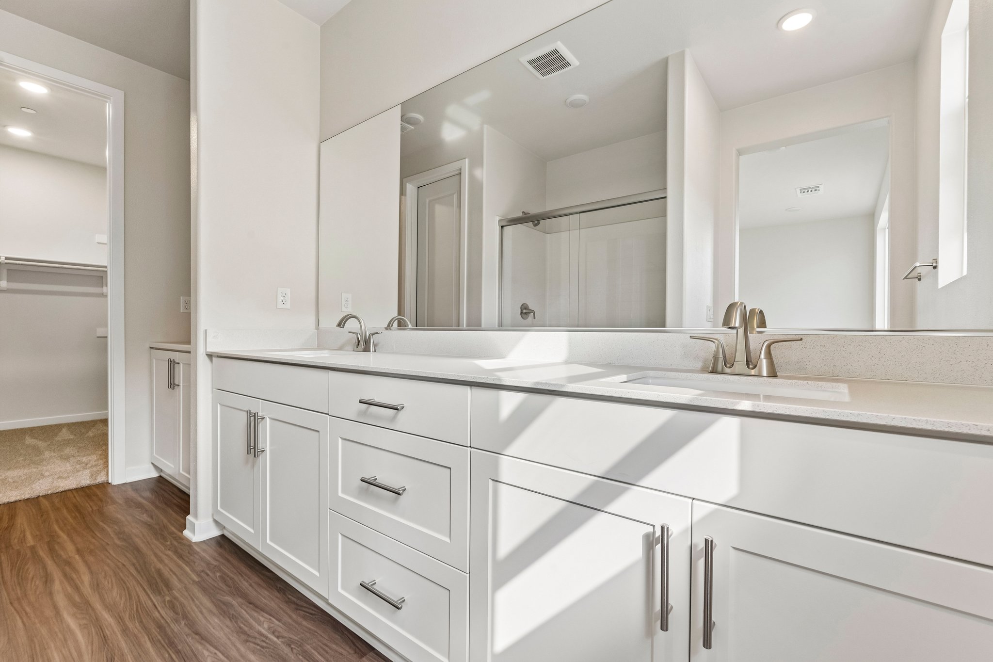 A bathroom with white cabinets.