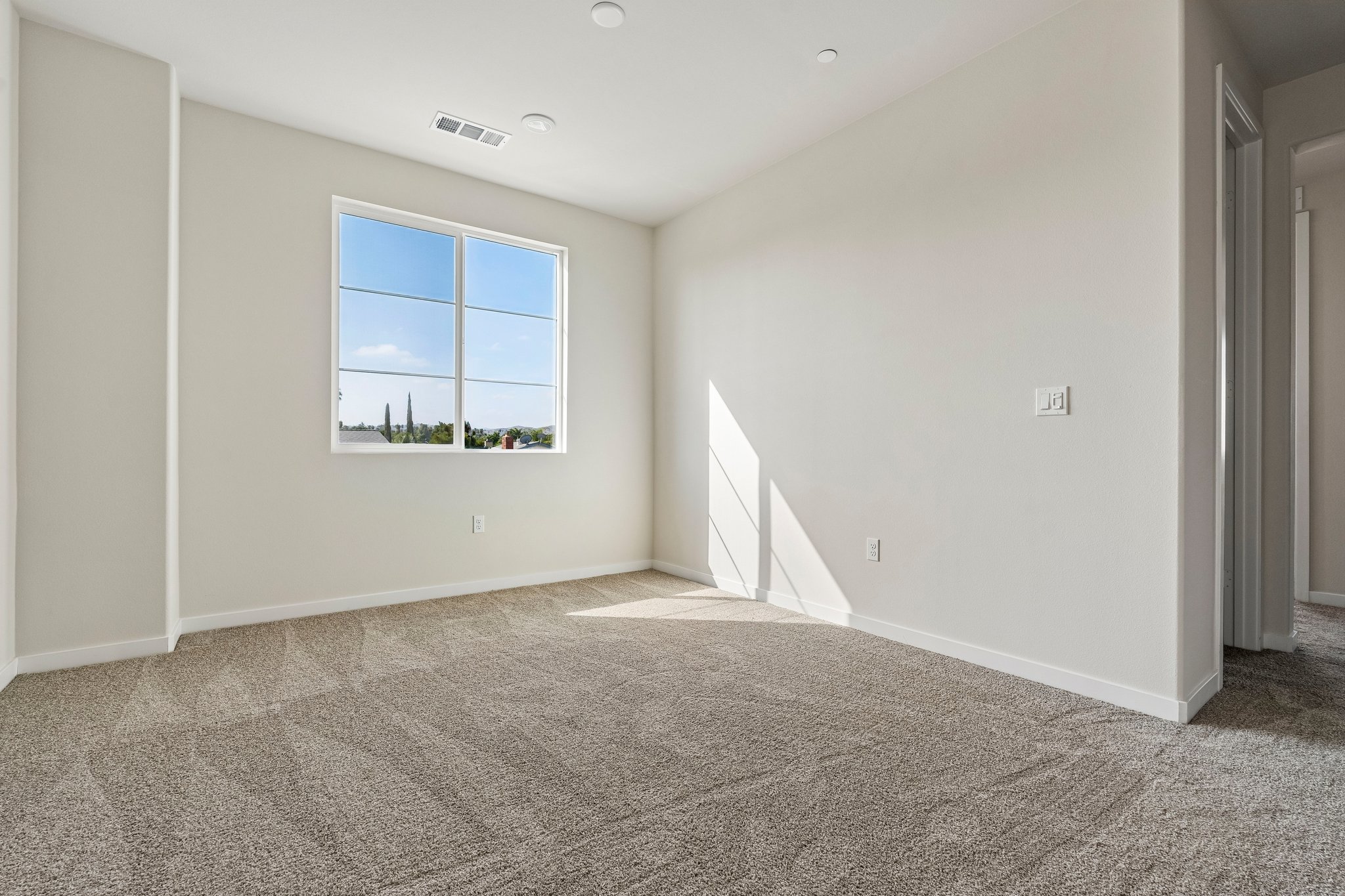 A room with a window and carpet.