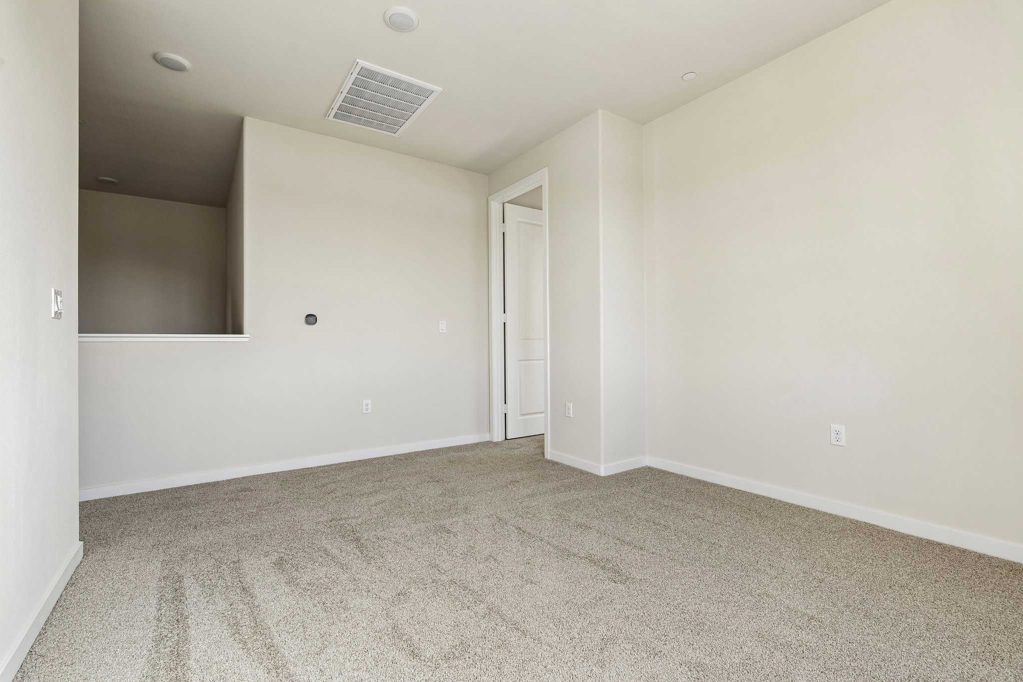 A room with a carpet and a door.