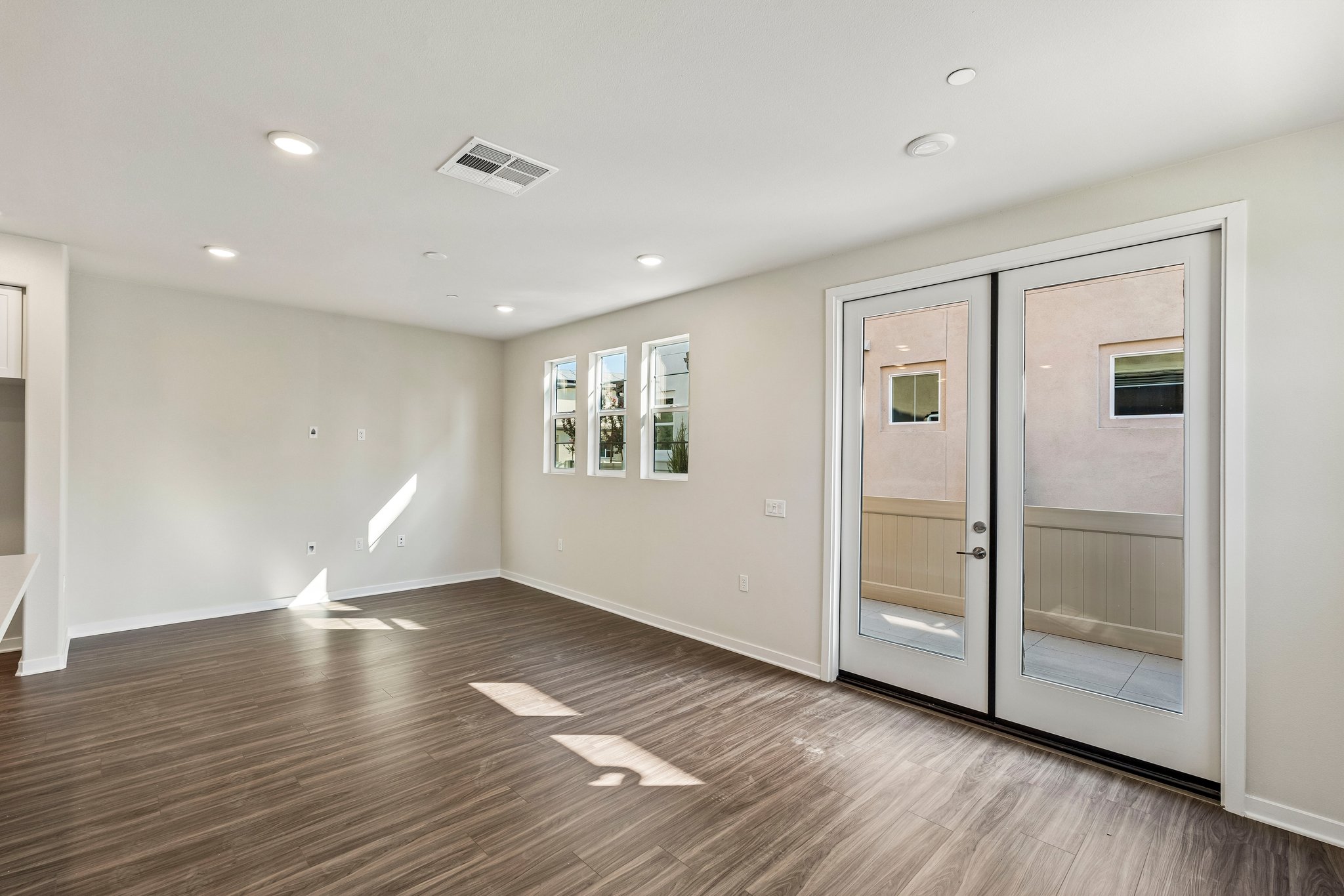 A room with a wood floor and a glass door.