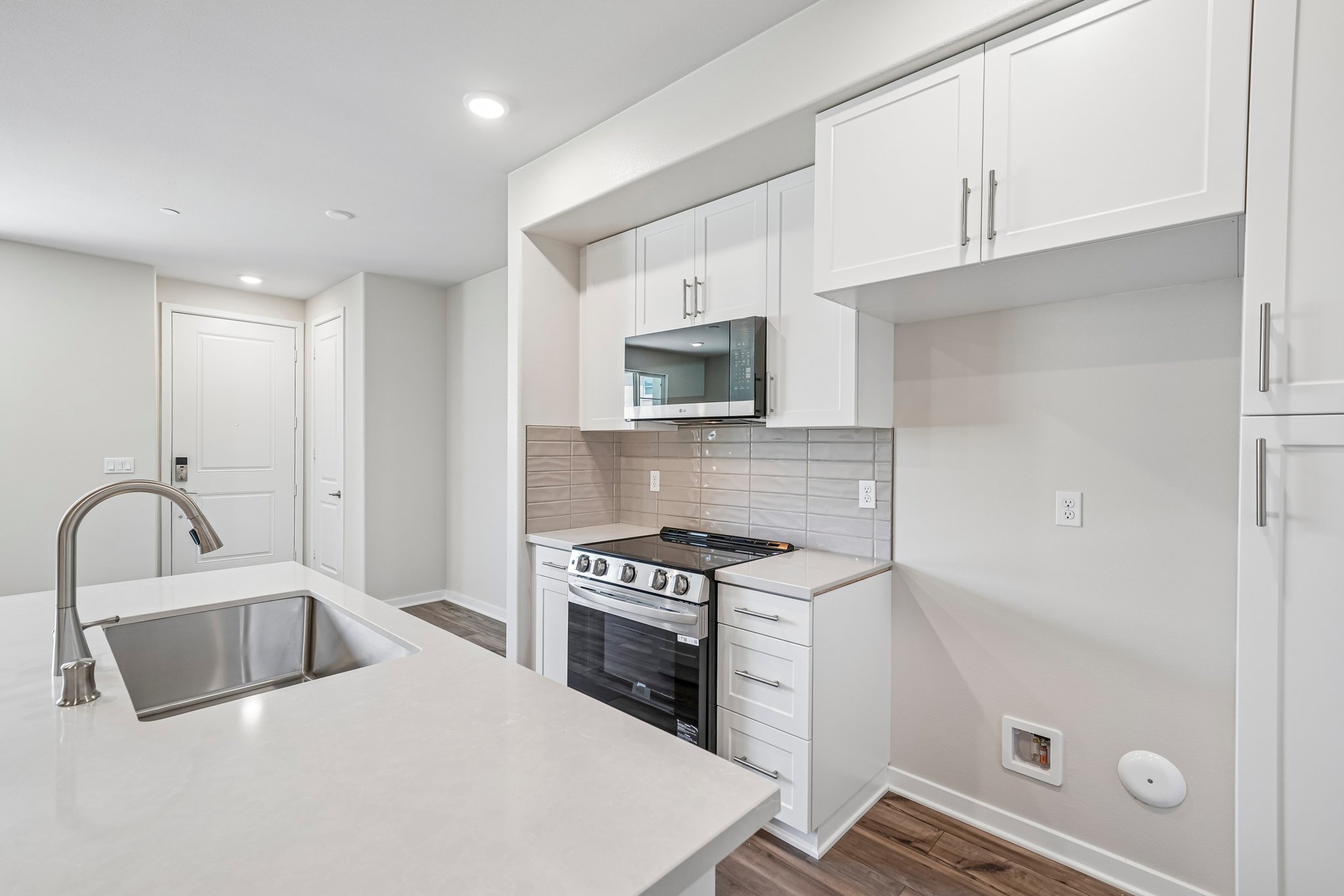 A kitchen with white cabinets.