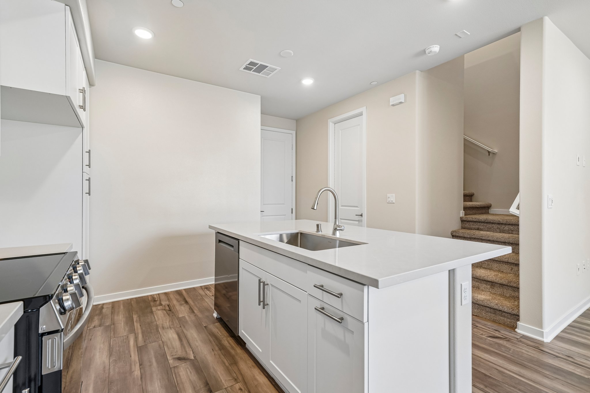 A kitchen with white cabinets.