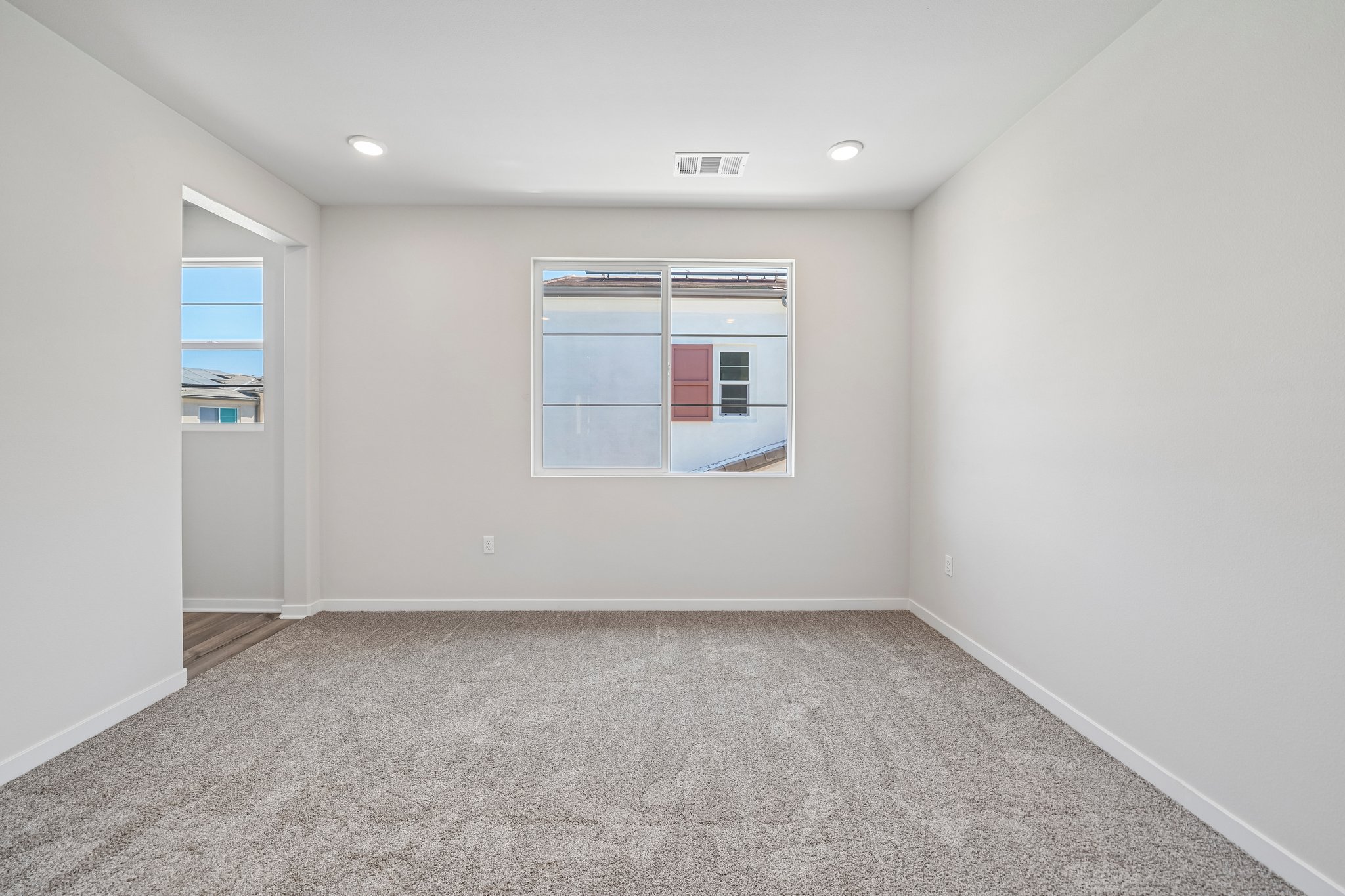 A room with a window and a carpet.