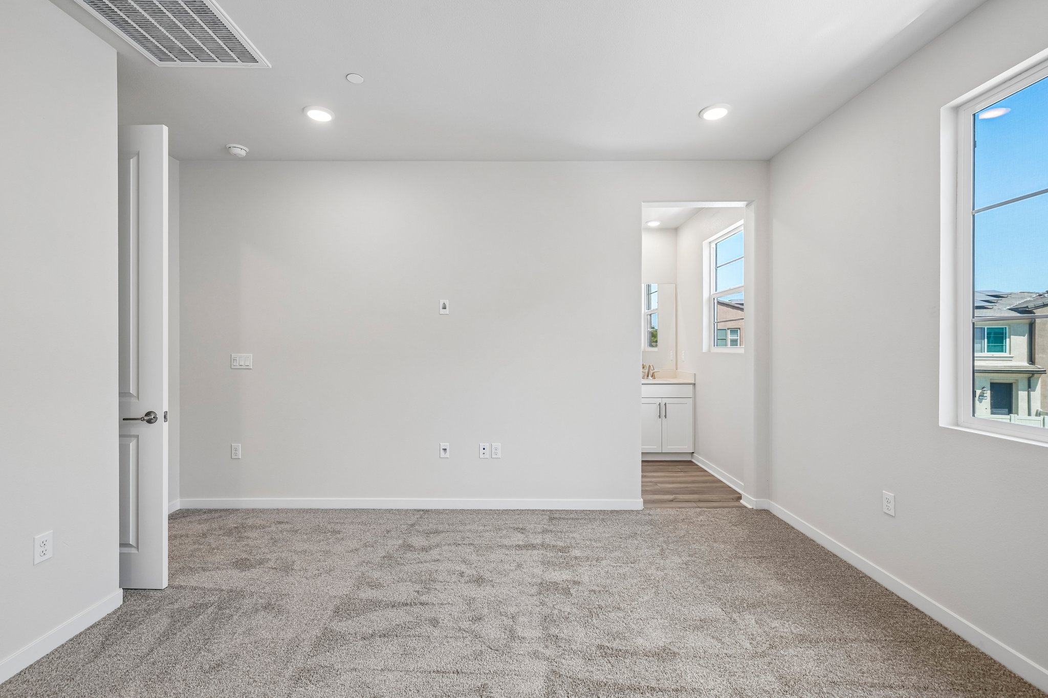 A room with a carpet and a window.