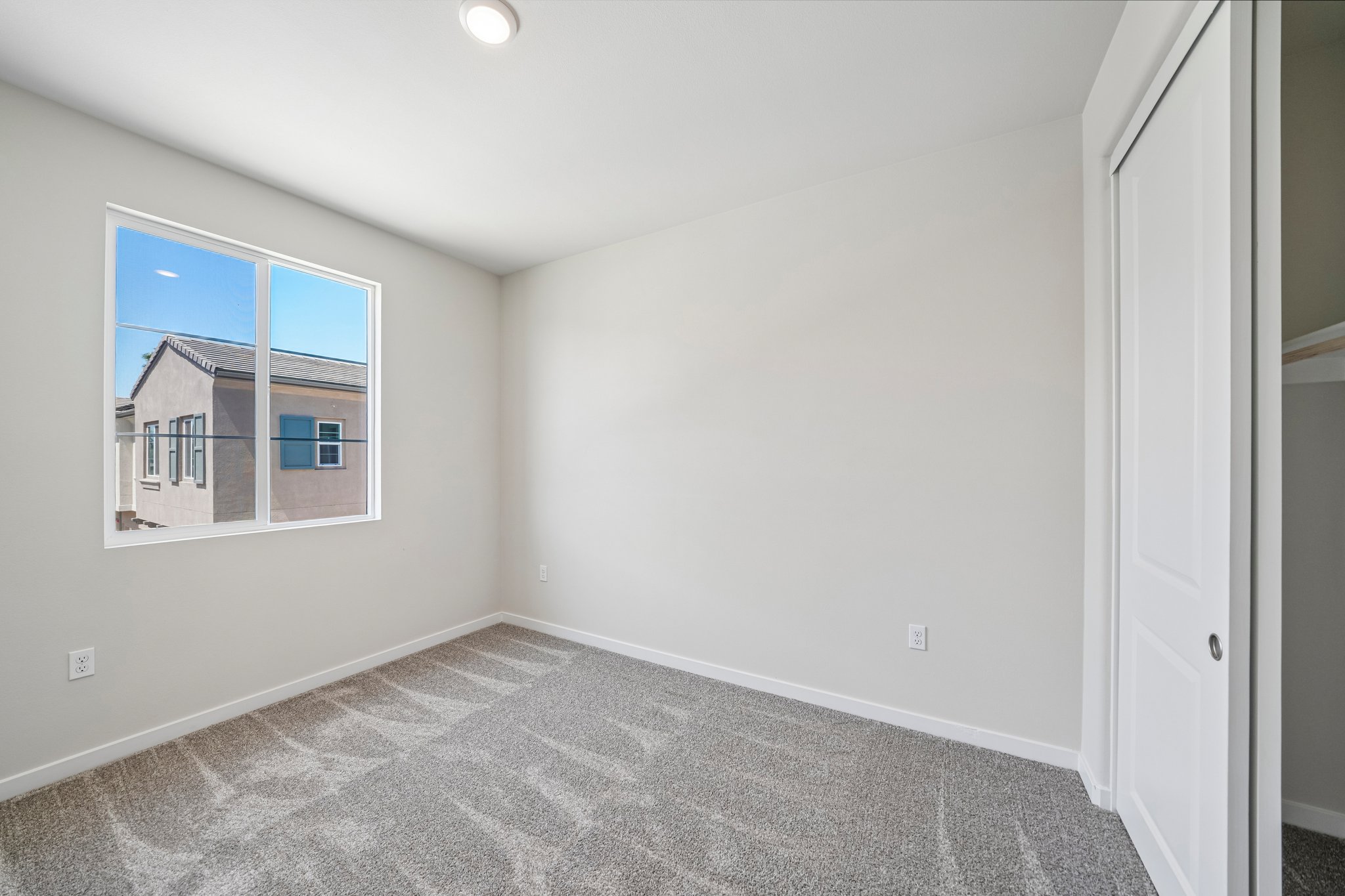 A room with a window and carpet.