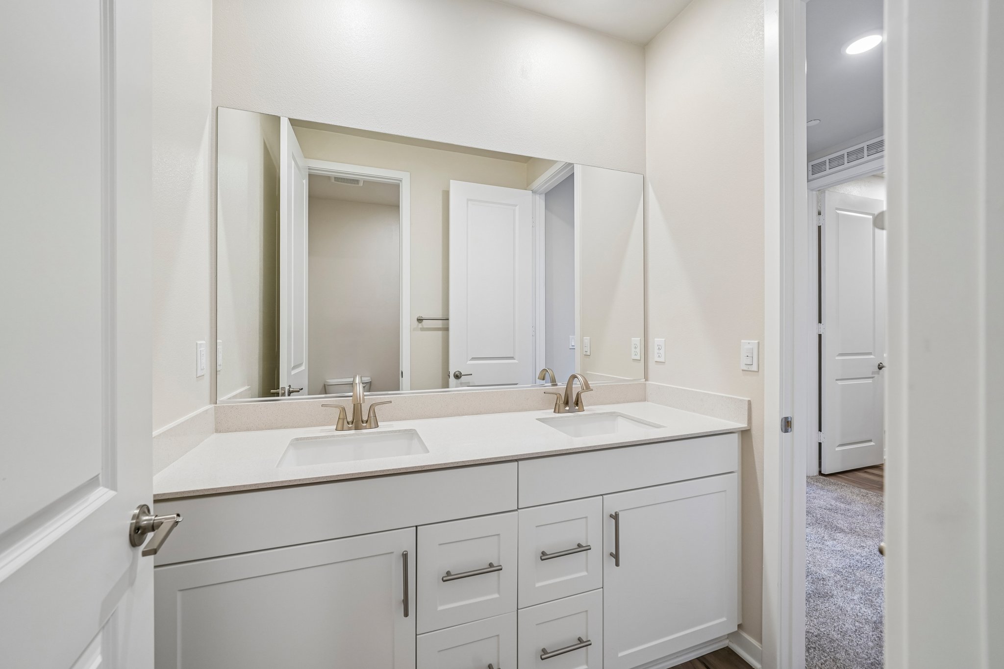 A bathroom with white cabinets.